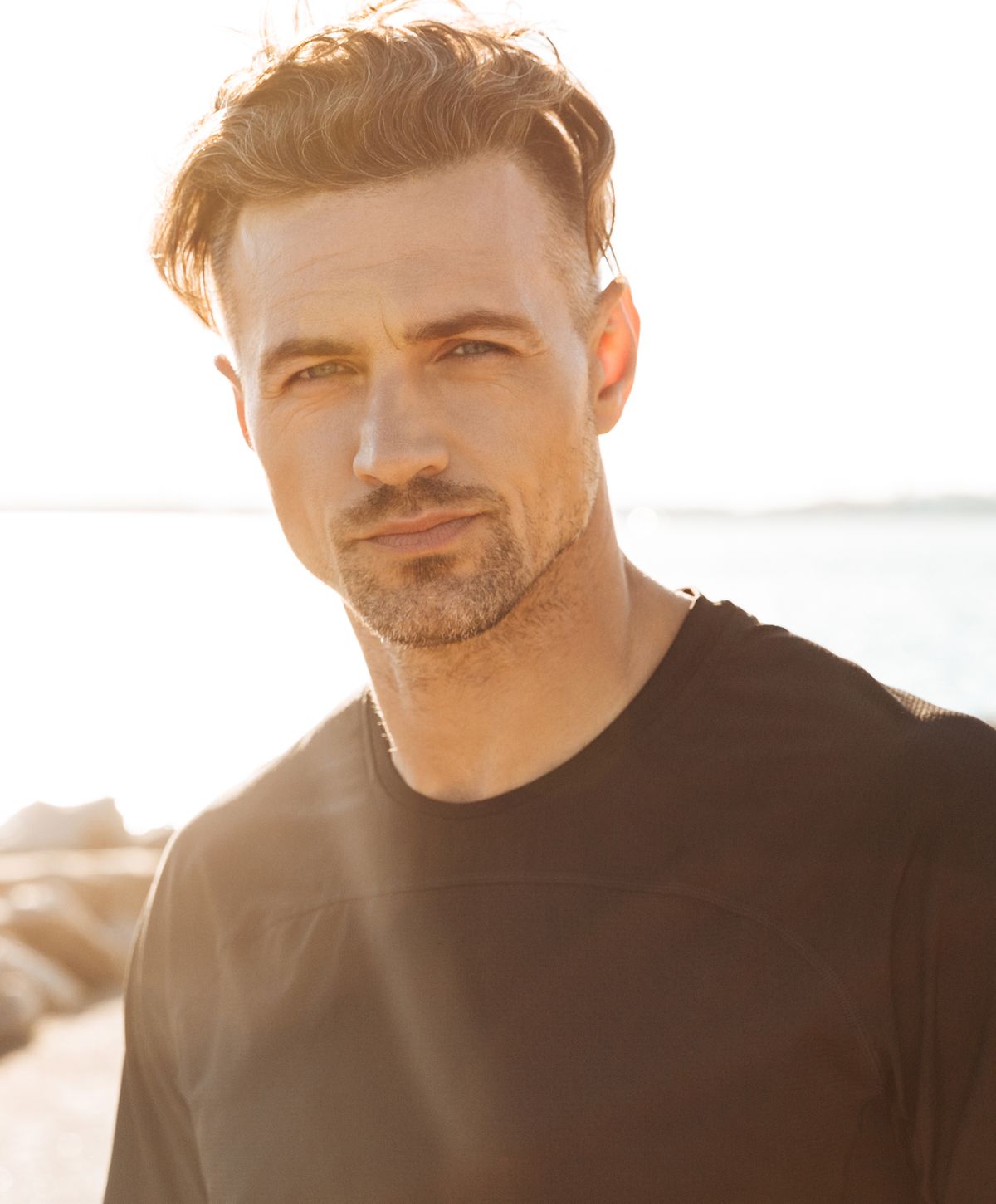 Man with short hair against sunny background.